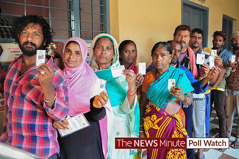 Image of voters standing in line at a polling booth.