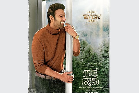 Prabhas sports a retro look in a brown coloured high- neck T- shirt and checkered pants in the image.
