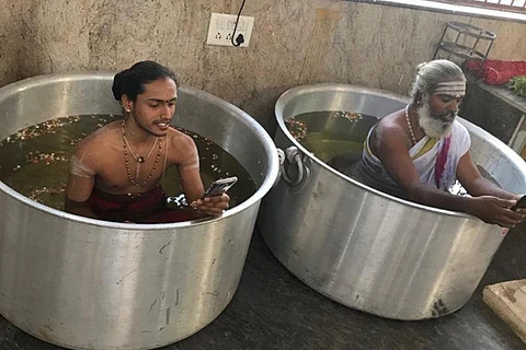To appease rain gods, Bengaluru priests sit in water-filled vessels with phones