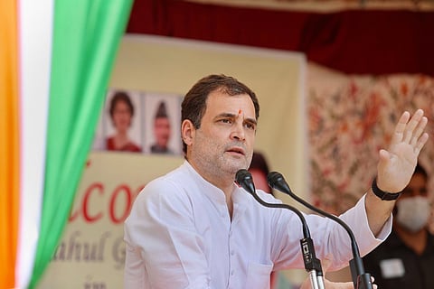 Rahul Gandhi wearing a white kurta, speaking into the mic at a party function