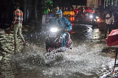 Hyderabad rains: A commuter wades through a waterlogged street during the monsoon season, at Malakpet in Hyderabad