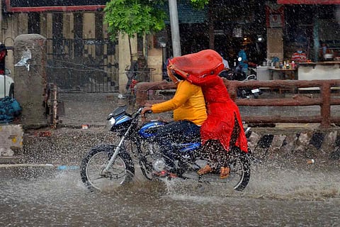Man and woman ride a bike in the rain