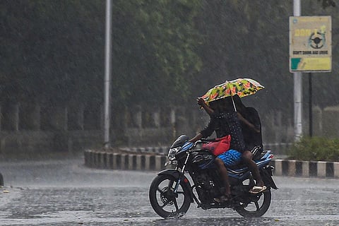 Two people seen riding on a bike amid heavy rains in Tamil Nadu
