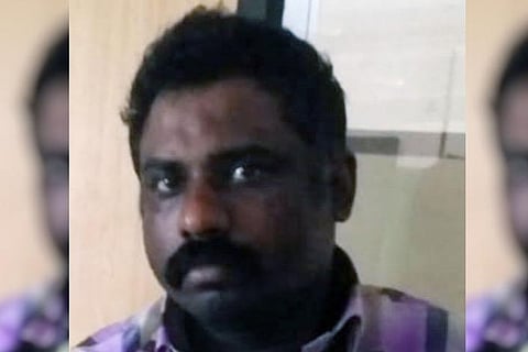 Deceased Raj Kumar. His close up photo where he is looking straight at the camera with a grim face.