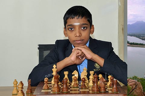 Indian chess prodigy Rameshbabu Praggnanandhaa posing for a photograph with a chess board
