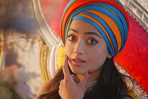 Rashmika Mandanna in a colourful headdress looking at camera