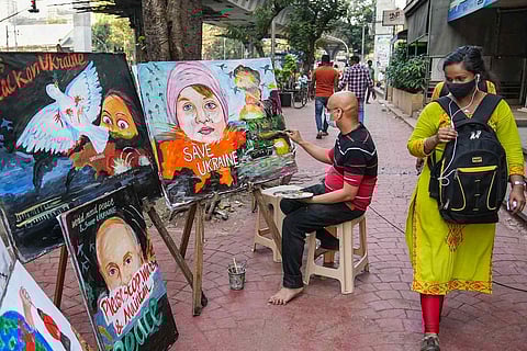 An artist works on a painting on the ongoing Russia-Ukraine crisis in Mumbai