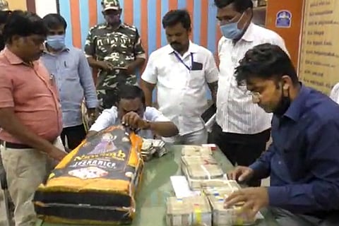 Six men standing around a table counting cash