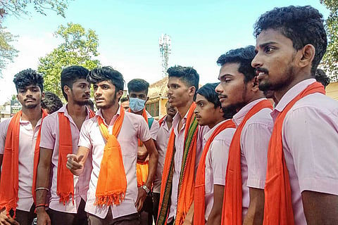 A group of students clad in saffron shawls