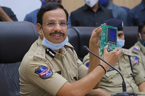 Cyberabad police commissioner Sajjanar holds up on the electronic chips that were seized