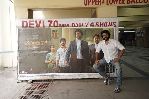 Actor Satyadev in front of his movie poster at Devi 70mm theatre in Hyderabad
