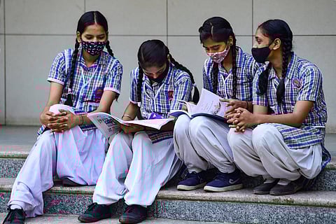 Four school girls looking into their textbooks; the Supreme Court has dismissed CBSE, ICSE students' plea for hybrid mode option in board exams