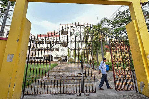A security guard standing near a school gate
