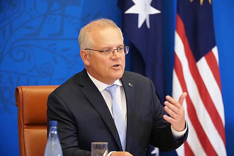 Australian Prime Minister Scott Morrison gestures while speaking to the media.