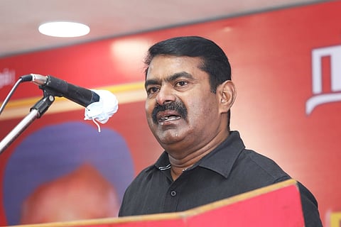 Naam Thamizhar Katchi leader Seeman speaking into a mic in a black shirt