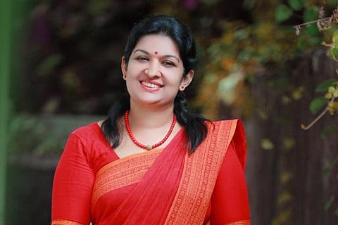 Piravom LDF candidate Sindhumol Jacob who was ousted from CPI(M). She is wearing a red saree, red chain and a red bindi.