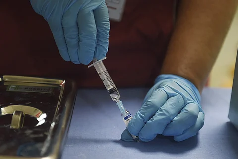 A health worker prepares a dose of the Sputnik COVID vaccine to administer to a beneficiary