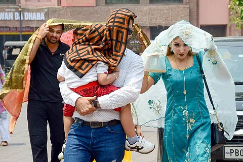 People cover themselves with pieces of clothes to shield themselves from the sun
