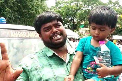 Mailaram Sushma's husband breaks into tears while holding his toddler daughter.