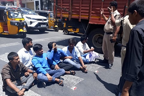 Students protest on road by blocking vehicles