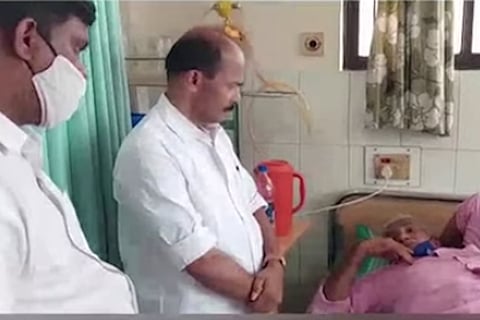 Two men standing next to another man who has been hospitalised after attack at a polling booth