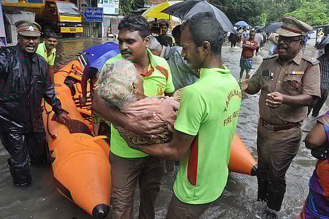 Fire department personnel rescuing an old women amid floods in Tamil Nadu