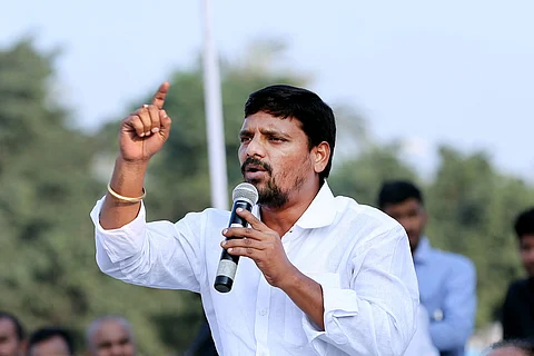Telugu TV host Teenmaar Mallanna speaking into a mic during election drive