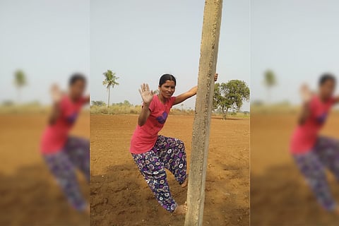 Bharathi poses for the camera before climbing the pole