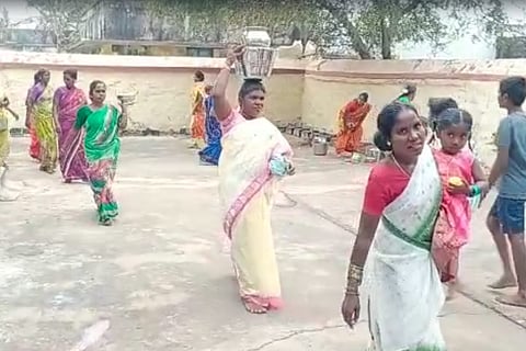 Woman with a pot on head inside a temple