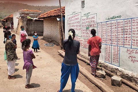 An older child teaching lessons to other children from a wall
