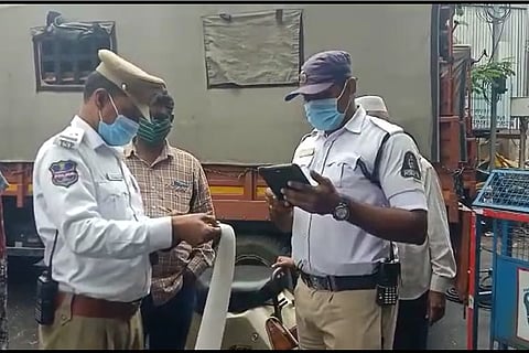 Hyderabad traffic police holding a long page with 127 unpaid traffic fines by a commuter