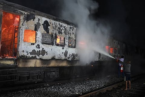 Firefighters dousing fire inside train coach