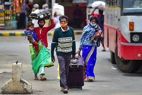 One man and two women travellers carry their luggage after alighting in Bengaluru