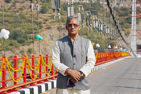 File photo of Trivendra Singh Rawat wearing a grey Nehru jacket standing on the Dobra-Chanthi bridge