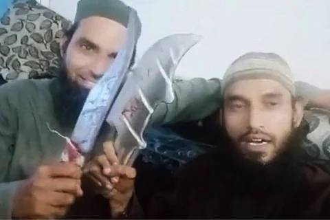 Udaipur murder: The accused men who hacked the tailor holding up the weapons in a video they shot of themselves