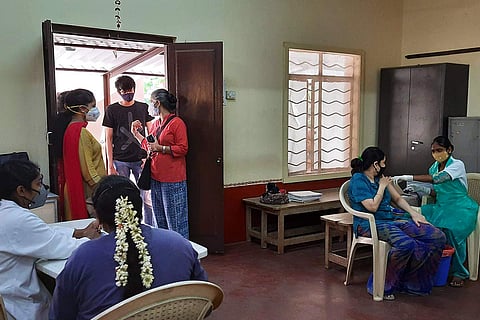 BBMP workers administering the COVID-19 vaccine to people at Vimarsha Charitable Trust