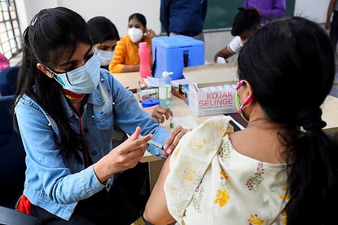 A health worker administers a dose of COVID-19 vaccine to a woman at a vaccination centre in New Delhi.
