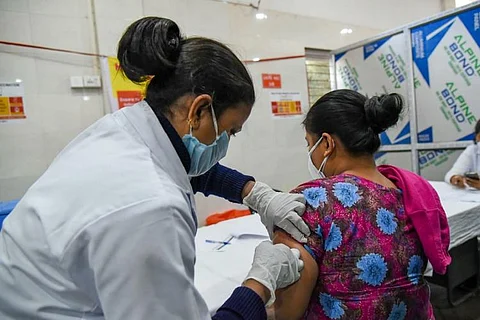 A health care staff administering COVID-19 vaccine to a beneficiary.