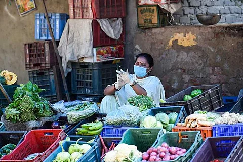 A vegetable seller sitting amid vegetables