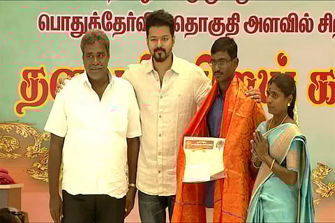 Actor Vijay felicitating a top student with parents at an event in RK Convention Centre, Chennai