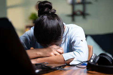 A woman resting before her laptop