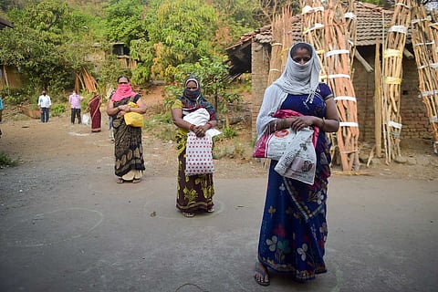 Women stand while distancing to collect ration at a store during nationwide Covid lockdown in a Maharashtra village