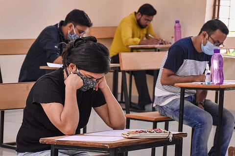 Students in masks writing exam