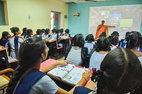Representative image of girls in school uniform attending a class inside a classroom