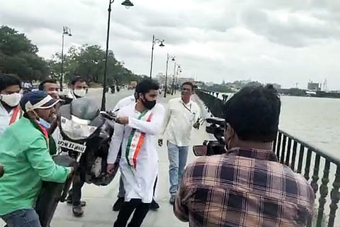 Youth Congress workers throwing a bike into a lake