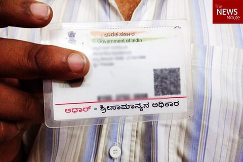 A man holding an Aadhaar card