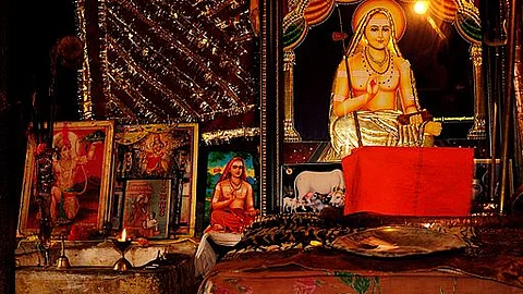A prayer room with framed pictures of various Hindu gods and saints. The largest of them is a picture of Adi Shankaracharya placed on the right side.
