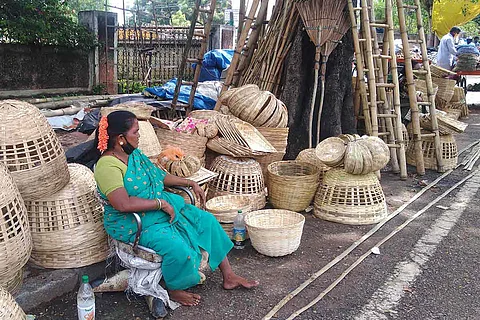 Medha tribal woman in green saree sitting with bamboo products