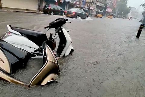 Two scooters fallen down on an inundated road during heavy rains in Chennai