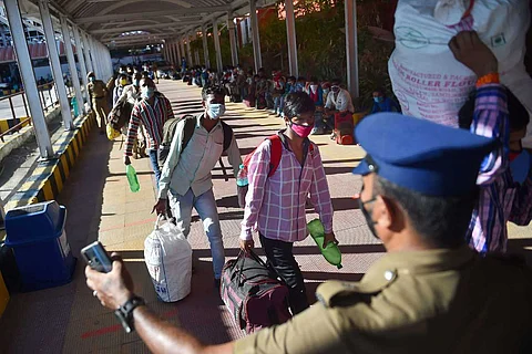 Chennai police assisting migrant workers to board a train